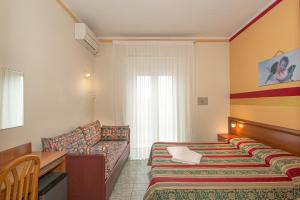Habitación de hotel con cama y sofá en Hotel Dolly, en Viareggio