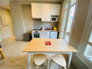 a kitchen with a wooden table and two chairs at Le Delfino PORT DE NICE in Nice