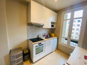 a small kitchen with a sink and a stove at Le Delfino PORT DE NICE in Nice