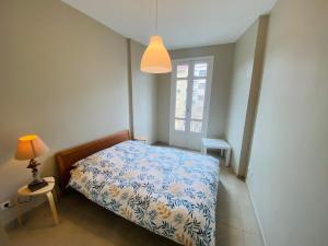 a bedroom with a bed and a lamp and a window at Le Delfino PORT DE NICE in Nice