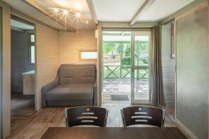 a room with a table and chairs and a couch at Camping Au pays de Hanau in Dossenheim-sur-Zinsel