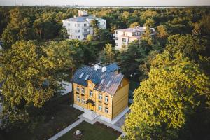 une vue sur une grande maison jaune avec un toit dans l'établissement Lenderi Villa Luxury Apartments with Sauna, à Tallinn