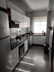 cocina con armarios blancos y fogones en Chaleureux Appartement à 1 min à pied de la Mosquée Hassan II, en Casablanca