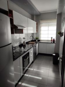 a kitchen with white cabinets and a stove top oven at Chaleureux Appartement à 1 min à pied de la Mosquée Hassan II in Casablanca