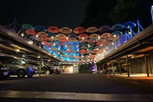 Une bande de parasols suspendus au-dessus d'un parking la nuit dans l'établissement ホテル 鳳凰 大人専用, à Hachioji