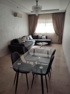 sala de estar con sofá, mesa y sillas en Chaleureux Appartement à 1 min à pied de la Mosquée Hassan II, en Casablanca