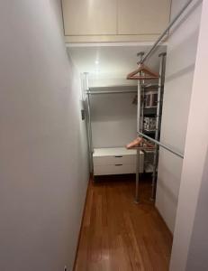 um pequeno quarto com um frigorífico e piso em madeira em Suite Luxury [Duomo - SanSiro] em Milão
