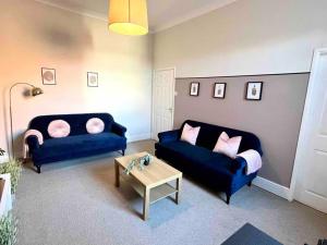 a living room with two blue couches and a coffee table at Close to city centre-Quayside bright apartment in Gateshead