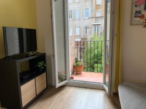 Cette chambre dispose d'une porte coulissante en verre s'ouvrant sur un balcon. dans l'établissement Marseille LOFT 50m2 au cœur du Cours Julien, à Marseille