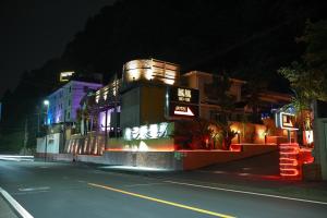 un bâtiment situé sur le côté d'une rue la nuit dans l'établissement ホテル 鳳凰 大人専用, à Hachioji