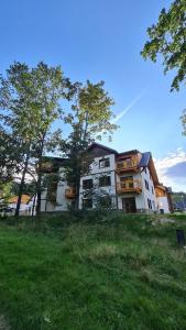 a building on a hill with trees in front of it at Apartament Dream Apart II in Szklarska Poręba