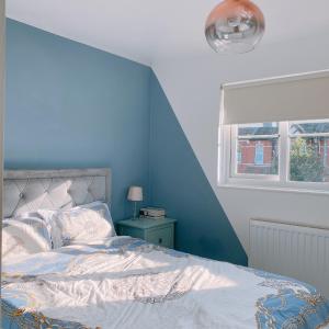 a blue bedroom with a bed and a window at Monalychee in London