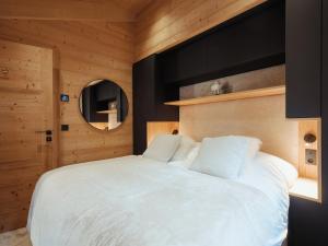 a bedroom with a white bed and a mirror at Chalet La Clusaz, 7 pièces, 10 personnes - FR-1-304-282 in La Clusaz