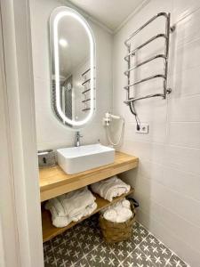 W łazience znajduje się umywalka, lustro i ręczniki. w obiekcie UGRAD family w Sławsku