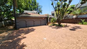 a house with a garage with a tree next to it at Casa Feliz in Mokopane