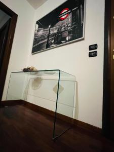 uma mesa de vidro num quarto com uma fotografia na parede em Appartamento tra Aeroporto DaVinci e Fiera di Roma em Fiumicino