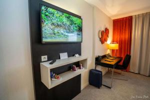 Zimmer mit einem Schreibtisch und einem TV an der Wand in der Unterkunft Best Western Plus Metz Technopole in Metz
