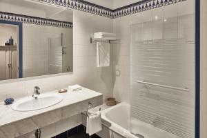 a white bathroom with a sink and a shower at Seaside Los Jameos in Puerto del Carmen