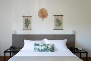 リド・ディ・イエゾロにあるHarvey Suites Hotel & Residenceの白いベッド1台、壁に3枚の絵が飾られたベッドルーム1室