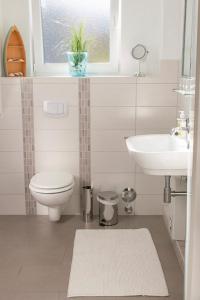 La salle de bains est pourvue de toilettes, d'un lavabo et d'une fenêtre. dans l'établissement Die Strandbutze - a74112, à Eckernförde