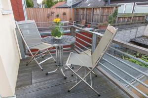 deux chaises et une table sur une terrasse avec une plante dans l'établissement Die Strandbutze - a74112, à Eckernförde