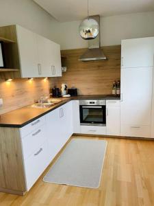 una cucina con elettrodomestici bianchi e pavimenti in legno di Wohnen am Remlerweg-FeelLikeHome a Mühldorf bei Feldbach
