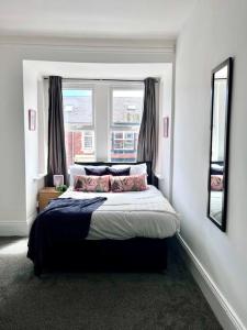 una camera da letto con un grande letto con due finestre di 5 BDRM house less than 10 mins to Newcastle a Gateshead