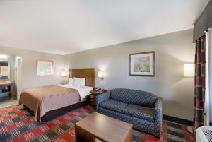 ナッキトッシュにあるQuality Inn near Parc Natchitochesのベッドと椅子付きのホテルルーム