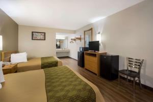 Habitación de hotel con 2 camas y TV en Econo Lodge, en Live Oak
