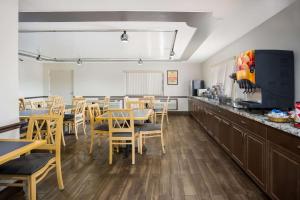 un restaurante con mesas y sillas de madera y una barra en Econo Lodge, en Live Oak