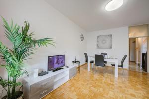 a living room with a television and a table with chairs at Top Of The Spots - Happy Rentals in Lugano