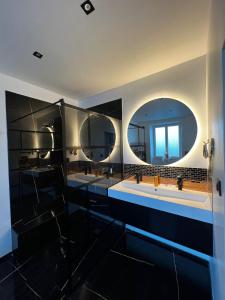 a bathroom with three sinks and a large mirror at Maison Cocooning 3 chambres double in Douarnenez