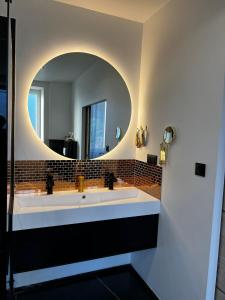 a bathroom with a large sink and a mirror at Maison Cocooning 3 chambres double in Douarnenez