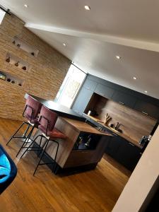 a kitchen with two stools and a counter top at Maison Cocooning 3 chambres double in Douarnenez