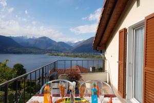 a table on a balcony with a view of a lake at Casa Esmeralda in San Nazzaro