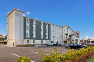 a large building with cars parked in a parking lot at WoodSpring Suites Jacksonville - South in Jacksonville