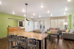 WoodSpring Suites Jacksonville - South في جاكسونفيل: غرفة طعام وغرفة معيشة مع طاولة وكراسي