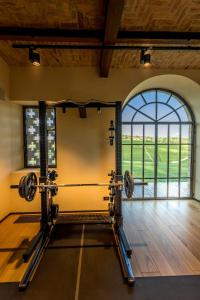 a gym with a barbell in a room with a window at Le Marne Relais in Costigliole dʼAsti