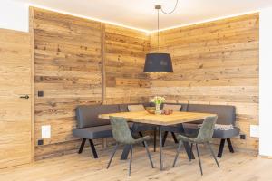 uma sala de jantar com paredes de madeira e uma mesa e cadeiras de madeira em Hideaway Dachstein West by ALPS RESORTS em Sankt Martin am Tennengebirge