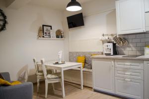 a kitchen with a white table and chairs in a kitchen at Donovaly Alonia in Donovaly