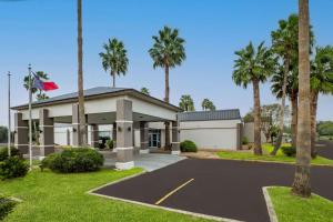 a house with palm trees in front of it at Quality Inn in Alice