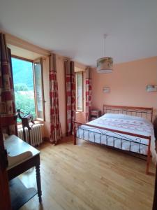 a bedroom with a bed and a large window at Maison Burgalat in Saint-Mamet