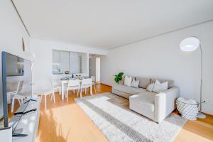 ein weißes Wohnzimmer mit einem weißen Sofa und einem Tisch in der Unterkunft Honeymoon with Stunning View - Happy.Rentals in Castagnola