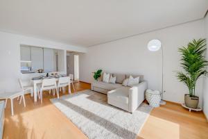ein weißes Wohnzimmer mit einem Sofa und einem Tisch in der Unterkunft Honeymoon with Stunning View - Happy.Rentals in Castagnola