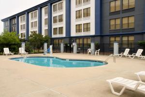 a building with a swimming pool in front of a building at Clarion Pointe Jacksonville near Camp Lejeune in Jacksonville