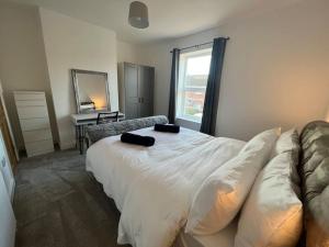1 dormitorio con cama, sofá y espejo en Stylish newly renovated home near Manchester City Centre, en Radcliffe