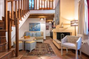 a living room with a staircase and a fireplace at The Varos Residences Hotel in Város