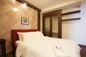 a bedroom with a white bed with a wooden headboard at 6c-cozy 25brs3bath In Bkk Downtown Btsmrtboat in Makkasan