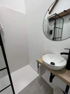 een badkamer met een witte wastafel en een spiegel bij Suites Chic in Herencia