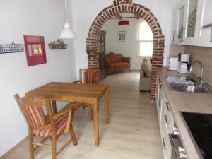 a kitchen with a table and a dining room at Ferienwohnung Elise im Gulfhof am Kanal in Großefehn 